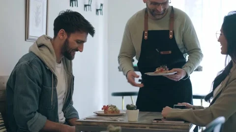 Video of handsome waitress man serving healthy and delicious toasts for smili Video stock 213293466