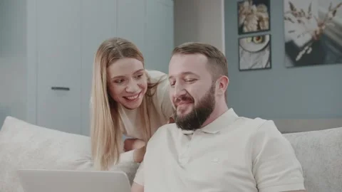 Video of happy beautiful couple using their laptop to searching voyage Stock Footage 234312897