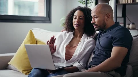 Video of happy beautiful couple using computer while sitting on the couch a.. Stock Footage 328186558