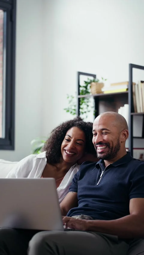 Video of happy beautiful couple using computer while sitting on the couch a.. Stock Footage 328186568