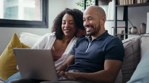 Video of happy beautiful couple using computer while sitting on the couch a.. Stock Footage 328186581