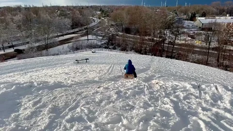 A video of a happy child sledding down a mountain in Germany Stock Footage 325648805