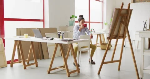 Video of happy female designer drinking coffee in studio Stock Footage 343365116