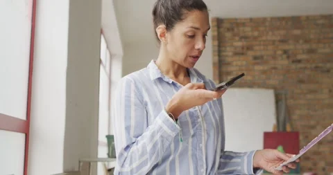Video of happy female designer using smartphone in studio Stock Footage 336783574