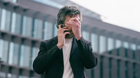 Video of happy mature businessman using smartphone while walking through th.. Stock Footage 340829331