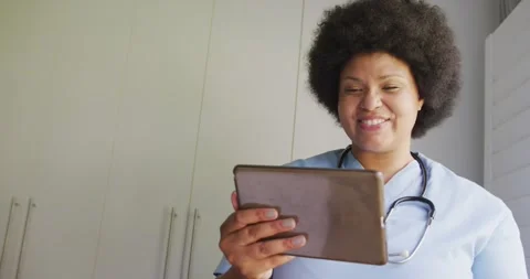 Video of happy plus size african american female doctor using tablet Stock Footage 337932037