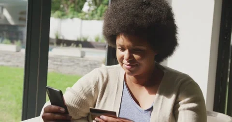 Video of happy plus size african american woman using two smartphones Stock Footage 344534187