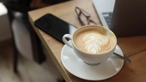 VIdeo of having rest drinking cup of coffee sitting on armchair. Black phone Stock Footage 238642093