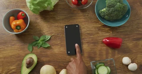 Video of healthy fruit and vegetables and smartphone on wooden background Stock Footage 344315536
