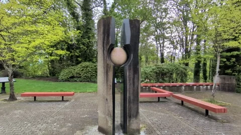 Video of an inviting park square showcasing an abstract sculpture Stock Footage 340925336