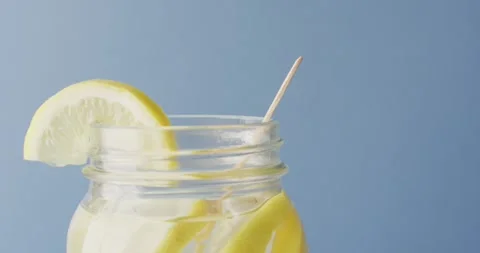 Video of jar with lemonade and straw on blue background Stock Footage 344324284