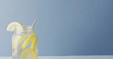 Video of jar with lemonade and straw on blue background Stock Footage 344338520