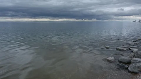 Video of a large lake with rocks along the shoreline. The water has small Stock Footage 335550003