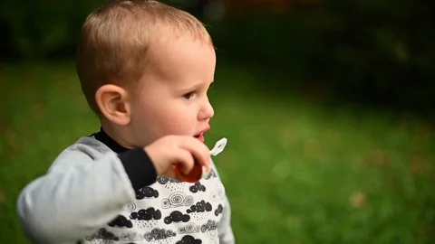 Video of a little boy having fun blowing soap bubbles on the lawn Stock Footage 124255403