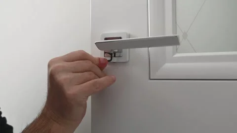 In the video, the locksmith adjusts the door handle with the hexagon tool Stock Footage 289543944