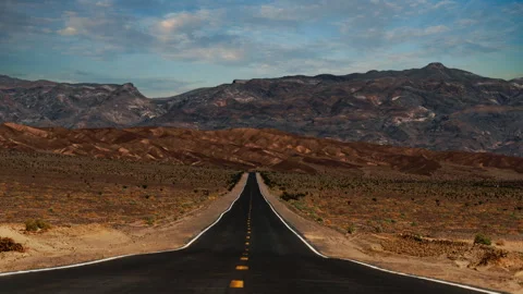 Video loop time lapse of clouds moving over empty desert highway in Death Stock Footage 346123433