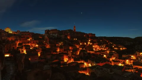 Video loop time lapse of clouds and stars moving over illuminated ancient old Stock Footage 346174707
