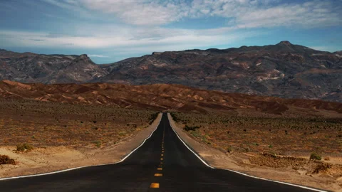 Video loop time lapse of clouds moving over empty desert highway in Death Stock Footage 346422077