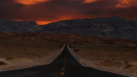 Video loop time lapse of clouds moving over empty desert highway in Death Stock Footage 346549751