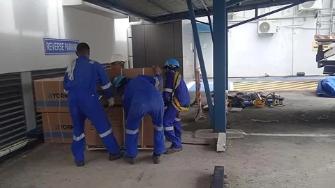 Video of Male Worker Unloading AC from Truck and Placing it on Cement Floor Stock Footage 305771466