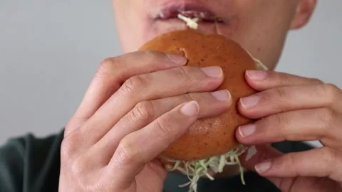 Video of a man eating a hamburger Stock Footage 323493101