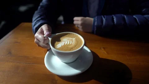 Video of a Man hands holding espresso coffee with latte art in a white mug. Stock Footage 334649077