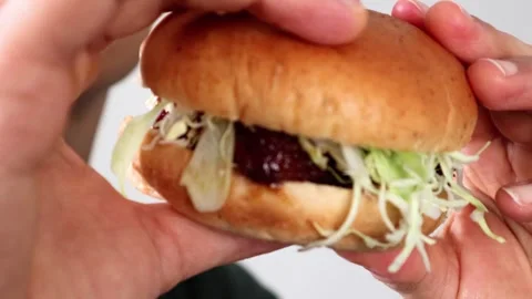 Video of a man holding a hamburger Stock Footage 323492956