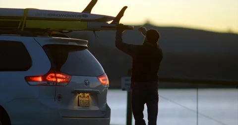 Video of man loading paddleboards at beach. 스톡 동영상 88372991