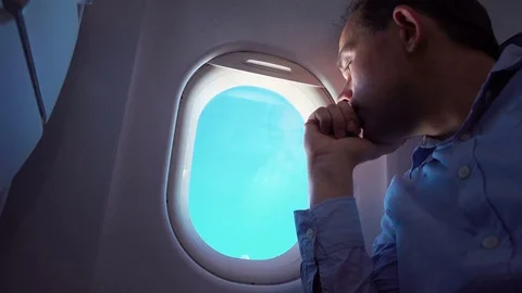 Video of man looking through the airplane window in 4K Stock Footage 77436441