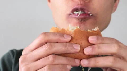 Video of a man posing after eating a hamburger Stock Footage 323492955