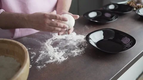 Video of a man putting a perfectly rounded pizza dough on a black plate 스톡 동영상 146551868
