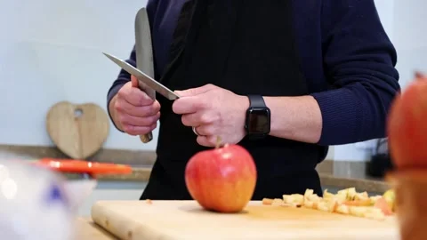 Video of man sharpening knives to cut some apples on a wooden board to make.. Video stock 297371109