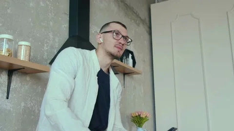 Video of a man sitting on the kitchen table and talking to someone on the phone Stock Footage 168997787