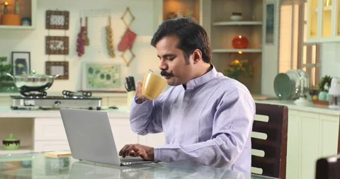 Video of Man Sitting At The Kitchen Table Working From Home On Laptop Stock Footage 255423956