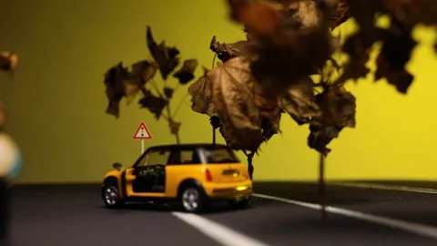 Video of a man sitting next to his yellow, new car figurine in the middle of  스톡 동영상 113240091