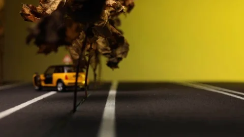 Video of a man sitting next to his yellow car figurine in the middle of a hig Stock Footage 113240758