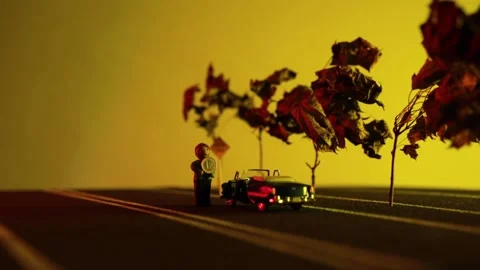 Video of a man sitting next to his blue retro car figurine in the middle of a Stock Footage 133493253