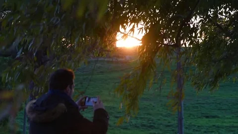 Video of a man taking pictures at sunset, selective focus Stock Footage 84006489