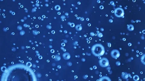 Video of many bubbles on an over blue backdrop with blurry details. The dark Stock-Footage 242747181