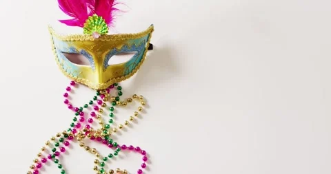 Video of masquerade mask with pink feathers and mardi gras beads on white Stock Footage 331307085