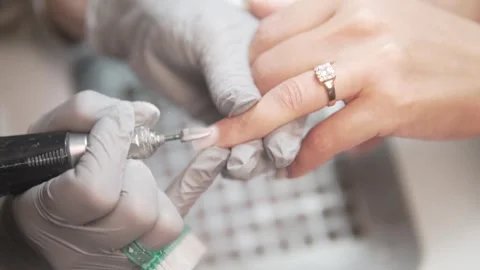 In the video, the master in gloves performs a hardware manicure, carefully Stock Footage 311047176