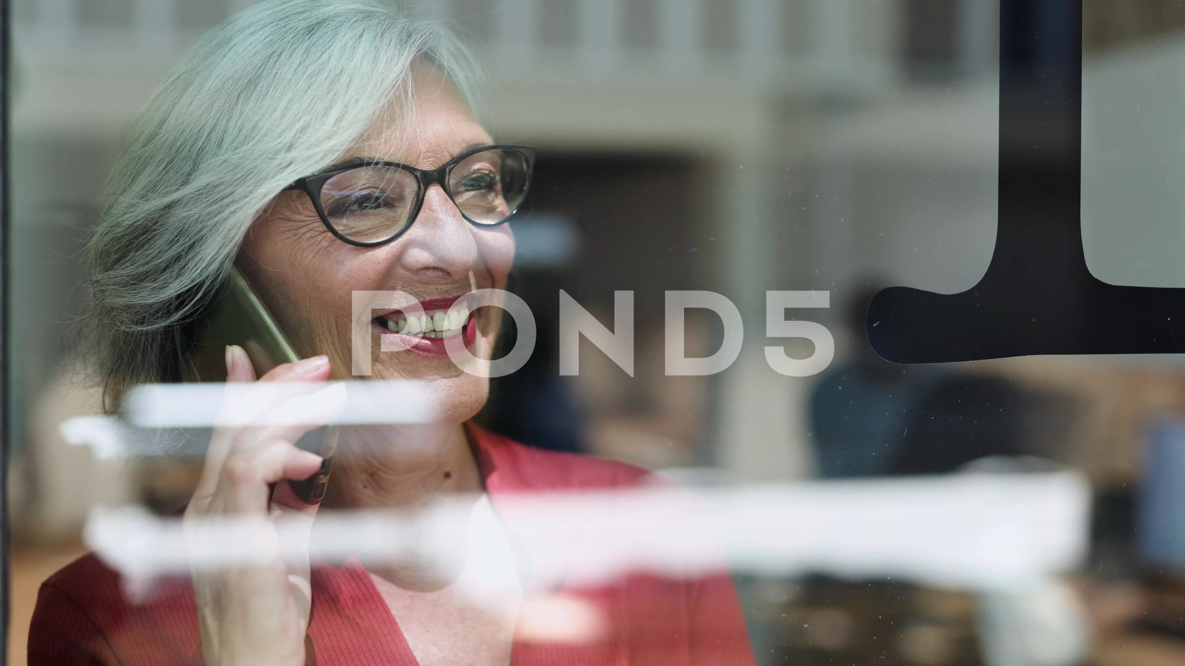 Video of mature business woman talking with smartphone in a coworking place