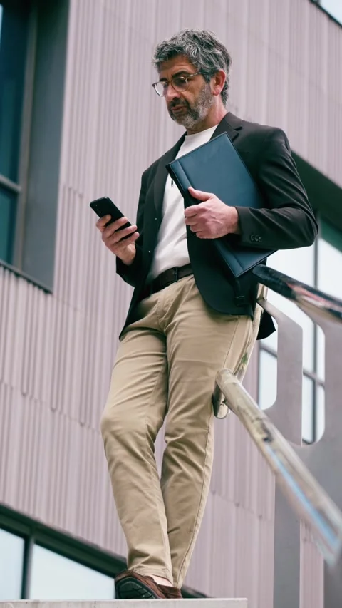 Video of mature elegant businessman using smartphone while staying in front.. Stock Footage 340829284