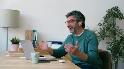 Video of mature man working while doing a videocall with laptop at the office Stock Footage 340829278