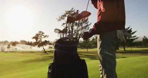 Video of midsection of african american man putting golf clubs into bag on golf Vídeos de archivo 343836321