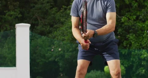Video of midsection of focused senior man playing tennis on tennis court Stock Footage 344849583