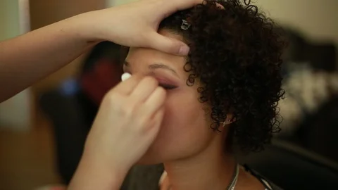 Video of a model having makeup applied by a makeup artist before a photoshoot. Видео 89904276