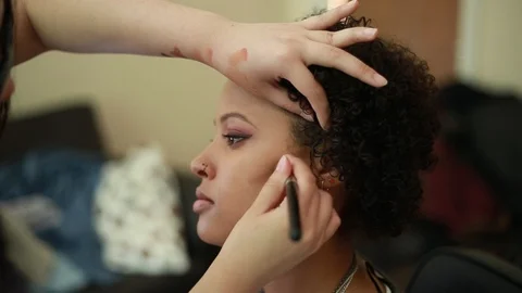 Video of a model having makeup applied by a makeup artist before a photoshoot. Видео 89905270