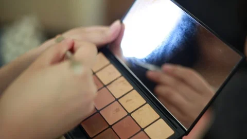 Video of a model having makeup applied by a makeup artist before a photoshoot. Видео 89923570