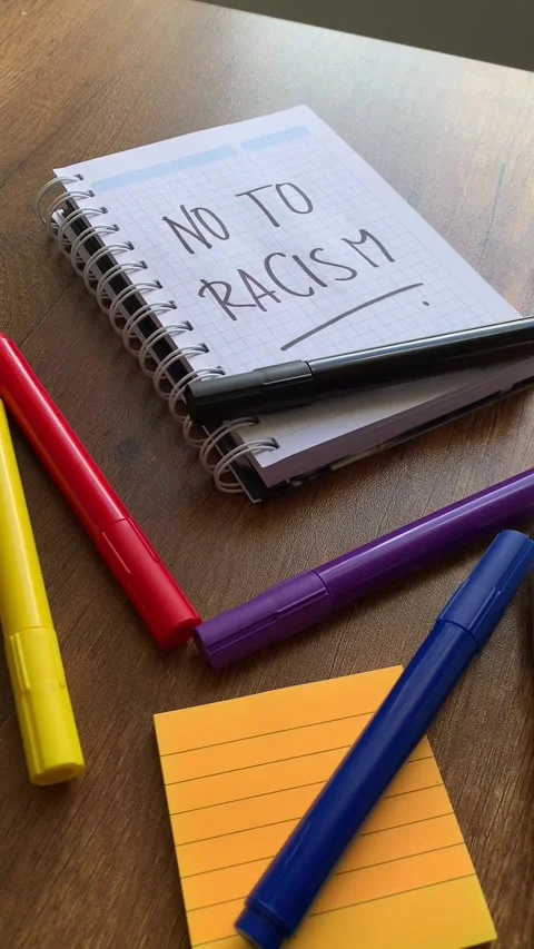 Video of a notebook with the phrase "no to racism" on a table. Stock Footage 262453175